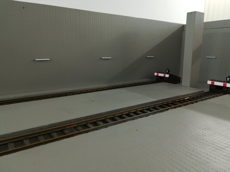 Die Bahnsteig-Platten im Schattenbahnhof-Süd sind verlegt. Blick auf die hintere rechte Wand mit Leuchtstofflampen.
